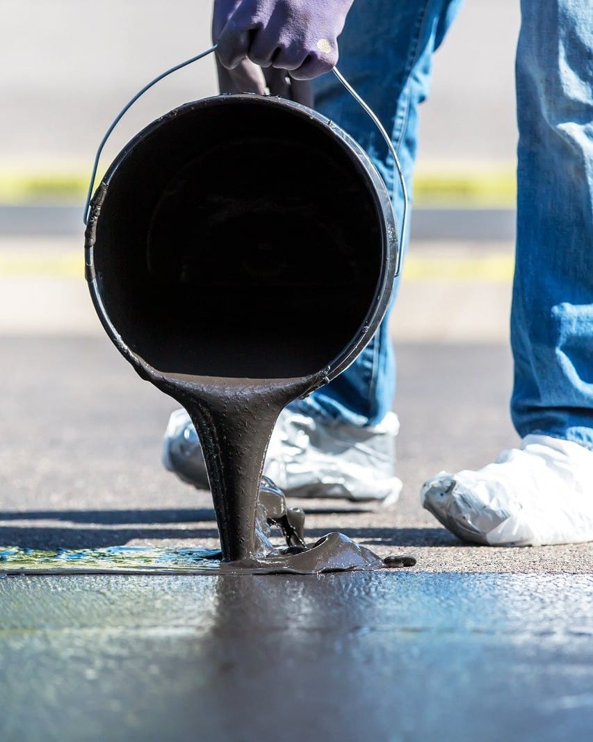 Pouring Black Tar Seal Coating Onto Driveway